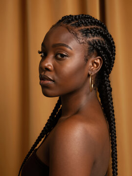 Side Profile Of Young Black Woman With Braided Hair And Gold Hoops