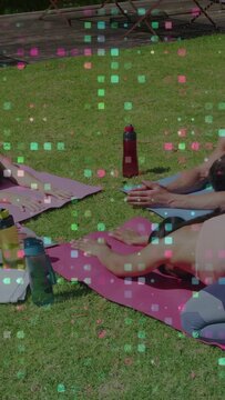 Vertical video: 3 adults in child pose on mats camera panning left showing pixels for yoga cooldown