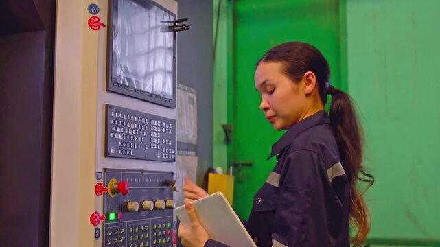 Machining precision female technician operating cnc machine in industrial workshop focused environment professional viewpoint