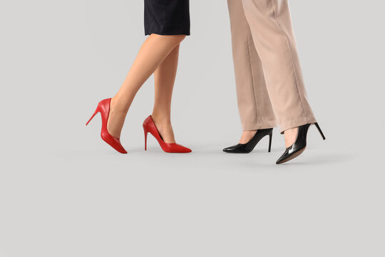 Legs of business women in high heels on light background