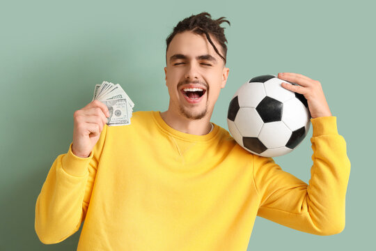 Happy young man with soccer ball and money on green background. Sports bet concept