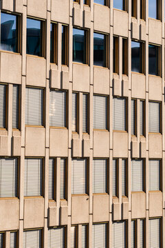Repetition of windows in a grid across a modern concrete building facade shows architecture pattern and texture as abstract minimal detail