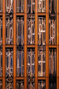 Abstract architecture facade of a building in orange metal lattice shows modern pattern and texture as a bold graphic surface detail
