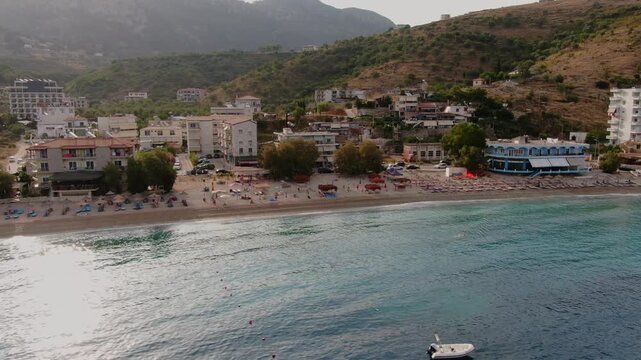 Idyllic aerial view of the town of Himare, with its beautiful beach on the Albanian Riviera coast during a sunny summer afternoon