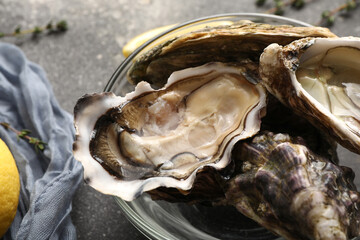 Glass bowl with delicious fresh oysters on dark background, closeup © Pixel-Shot