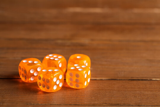 Orange game dices on wooden background