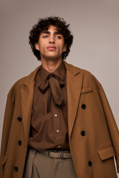 Stylish young man showcases modern fashion with elegance in a warm color palette