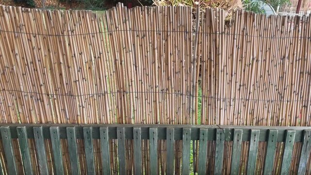 Bamboo fence panel with vertical wooden slats, ideal for garden privacy and texture background