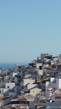 White houses under a clear blue sky at sunset, Torrox, Spain. 4K Vertical