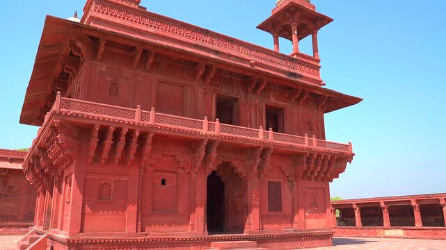 A smooth tilt down shot revealing the full exterior of the Diwan-i-Khas (Hall of Private Audience), showing its ornate red sandstone architecture and chhatris in Fatehpur Sikri.