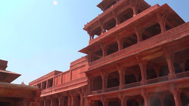 A low-angle static shot of the Panch Mahal, a unique five-story palatial structure made of red sandstone, showcasing its columnar architecture in Fatehpur Sikri.