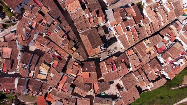 Top-down view of Ain village in Spain revealing dense terracotta rooftops, narrow winding streets and traditional Mediterranean architecture in a compact historic layout