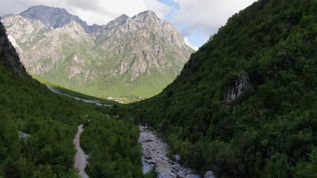 Stunning aerial view flying through the Theth Valley in Albania. Majestic Accursed Mountains and a winding riverbed creating an epic vista
