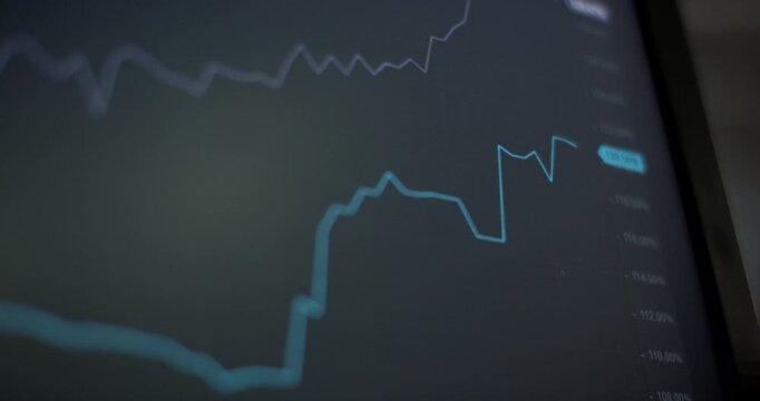 Close-up of a digital screen displaying a blue linear financial stock market graph with a blurred dark background