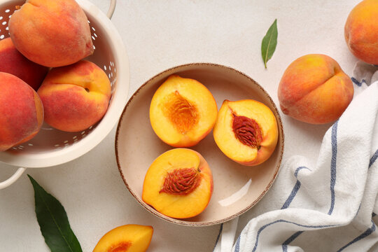 Bowl and colander with sweet ripe peaches on white background