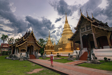Obraz premium Golden Wat Phra Singh temple at sunset with cloudy sky, Chiang Mai, Thailand 