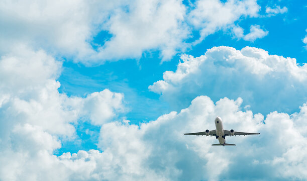 Under view of commercial passenger airplane flying in blue sky, aviation travel concept showing flight after takeoff or before landing, global air transportation for vacation and international journey