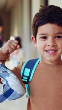 Friends, children and flex with face at school for goals, success and happy with support for education. Kids, smile and portrait with bicep, muscle and confidence for learning in hallway at academy