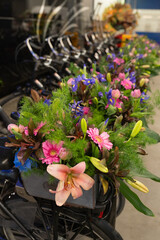 Fototapeta premium Bicycle handlebars and racks are decorated with fresh flowers, celebrating a festive event or cultural festival in the Netherlands, with colorful blooms attached to parked bikes. Dutch festival