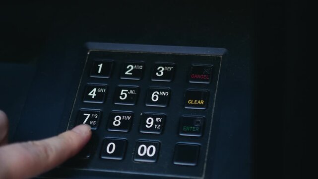 Close-up of ATM keypad as a bank customer enters a PIN code using fingers. The scene represents banking security, cash withdrawal, and digital financial transactions. High quality 4k footage