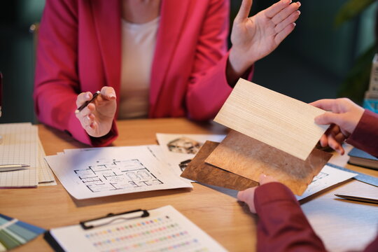 In a creative meeting setting, two individuals enthusiastically discuss interior design options.
