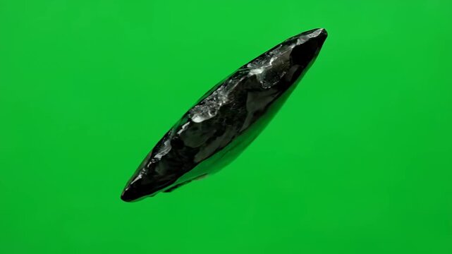 Polished Black Obsidian Arrowhead with Concentric Rings Rotating on Green Screen Background