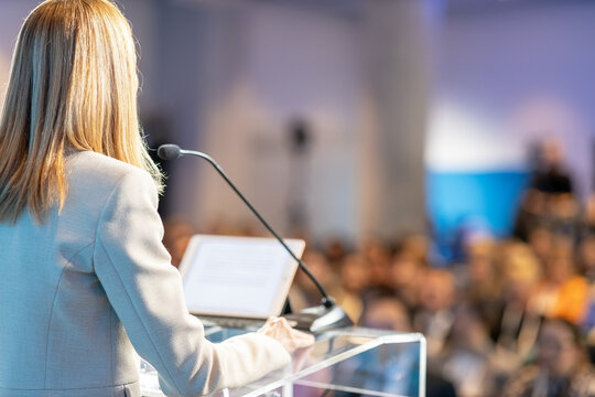 Female public speaker at business conference, corporate presentation, workshop, coaching training, news conference, company meeting, public or political event. Public speaking concept.