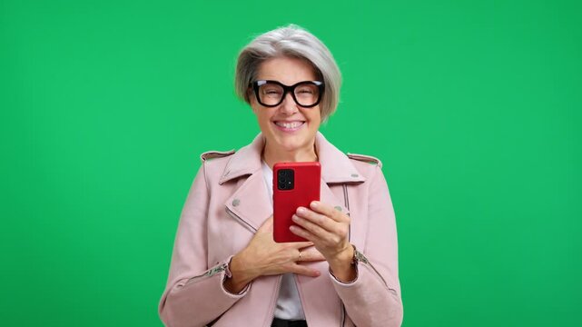 Mature woman celebrating winning on smartphone