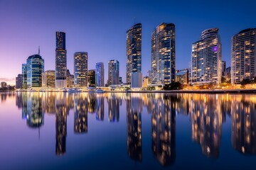 Obraz premium Bright city lights evoke awe and serenity at dusk's peaceful reflection.