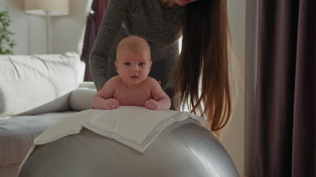 Mother and baby engage in playful exercise on a stability ball, promoting development and bonding