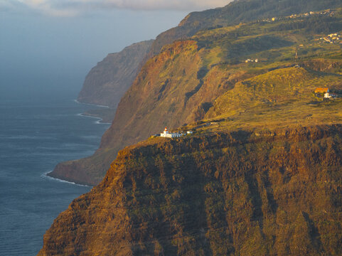 Aerial view of the Ponta do Pargo Lighthouse situated on the edge of dramatic volcanic cliffs above the Atlantic Ocean at sunset in Ponta do Pargo, Madeira, Portugal.