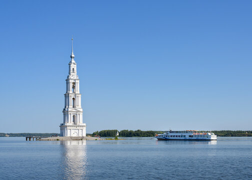 The bell tower of St. Nicholas Cathedral (built in 1800), which remained after the flooding of part of the city of Kalyazin by a reservoir on the Volga River, and a tourist ship