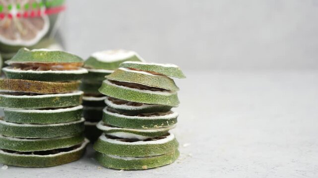 Thinly sliced dried limes stacked in piles slow motion detail food ingredient.