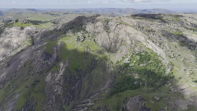 Drone orbits right in ultra wide shot of rocky summit on a sunny day at Sibebe Rock near Mbabane, Eswatini