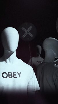 A group of faceless spinning mannequins and political statements contained on street signs on an endless loop.
