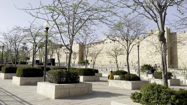Jerusalem, Israel, April 17, 2026. View of the Old City walls through trees with budding leaves near Jaffa Gate.