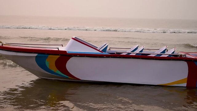 A morning coastal video footage taken at Digha Beach, India, featuring a single-hull fibreglass boat swaying in the gentle waves beneath a soft, hazy sky. Ideal themes for travel, tourism, and nature.