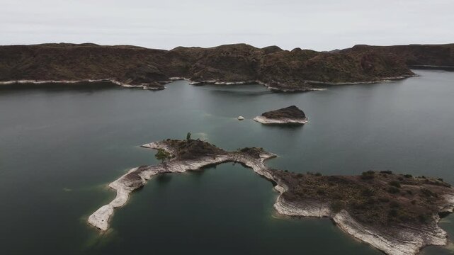 Aerial view of lake Los Reyunos in Mendoza, Argentina, on a dark, overcast day.