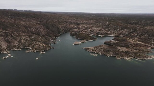 Aerial view of lake Los Reyunos in Mendoza, Argentina, on a dark, overcast day.