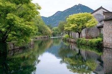 Obraz premium ancient chinese village by the river, with stone houses and lush greenery along its banks. the clear water reflects the surrounding mountains and trees
