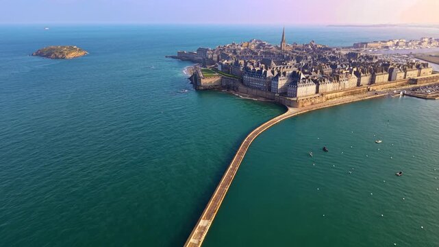 Beautiful backward drone fly from the long causeway Mole des Noires with distant Intra Muros district, Saint-Malo, Ille-et-Vilaine, France