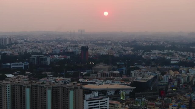 Aerial view of cityscape with sun, haze and sky at Bengaluru, karnataka, india. day time, jib shot, push back shot, drone shot, 4k.