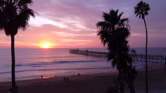 Beautiful Sunsets Silhouette of Palm Trees in the foreground. Pier Overlooking the Sunset on beach. San Clemente, Orange County, California