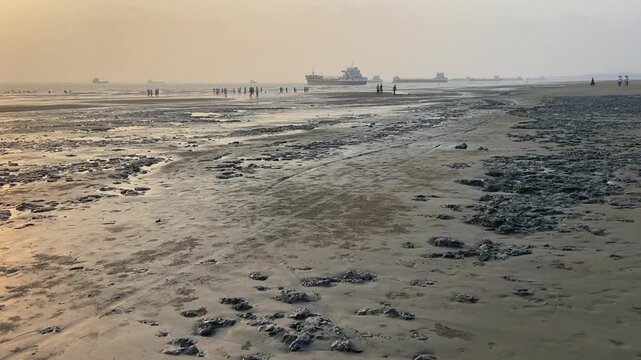 Sunset over Parki Sea Beach with Cargo Ships and Muddy Shoreline, Chittagong, Bangladesh