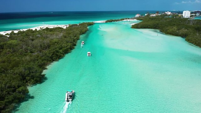 Boats navigate vibrant blue channels surrounded by lush greenery and sandy beaches. Ideal for travel and nature content.