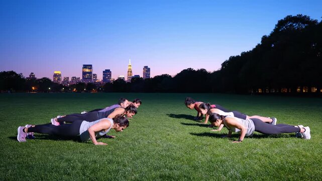 a diverse fitness group performing synchronized push-ups in a city park at dawn. Features professional form and a serene blue-hour atmosphere with soft violet skies, capturing morning discipline and c