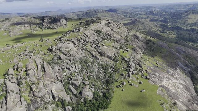 Drone orbits to the right in wide shot of rocky summit on a sunny day at Sibebe Rock near Mbabane, Eswatini