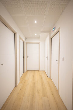 Un bureau, appartement neuf avec 5 portes ferm&eacute;es, les murs sont blancs et l'encadrement est en bois, le sol est un parquet en bois