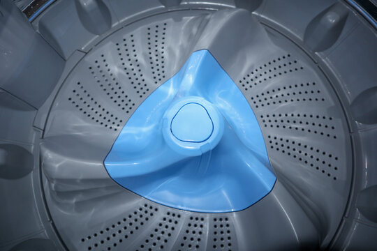 Top view close up of a gray and blue washing machine pulsator plate