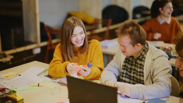Young students engage in an interactive learning activity with a molecular model and laptop. A group of diverse learners collaborate cheerfully on a science project in a classroom setting.